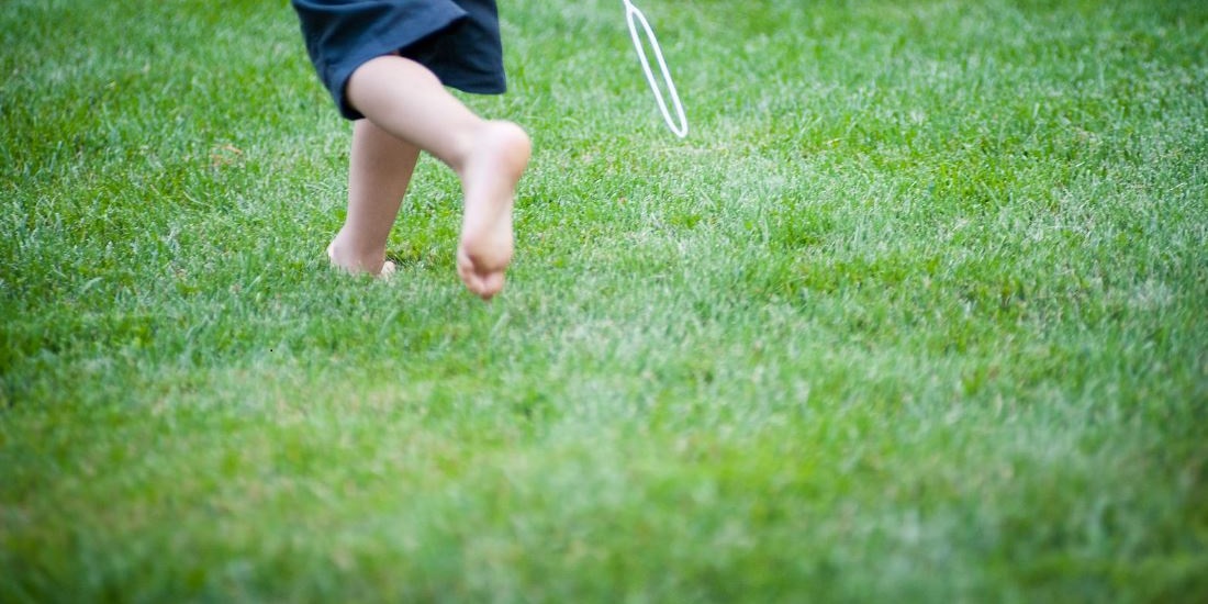 Child playing on a residential lawn with new sod